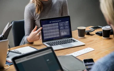 portfolio-management-woman-pointing-at-a-laptop-displaying-data