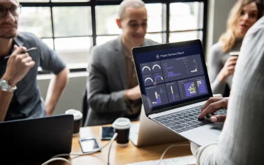 project-management-group-of-people-in-a-meeting-and-a-laptop-showing-charts
